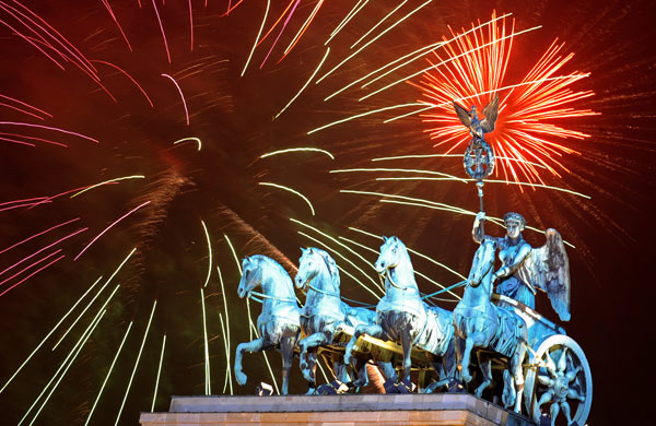 Fireworks explode behind the quadriga of Berlin's landmark Brandenburg Gate.