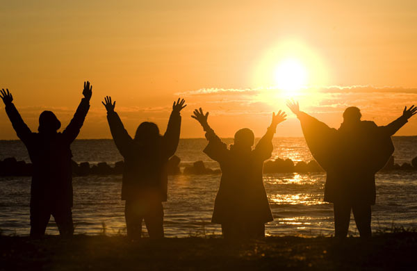 Young Japanese celebrate of the first sunrise of the year at Misaki beach in Japan