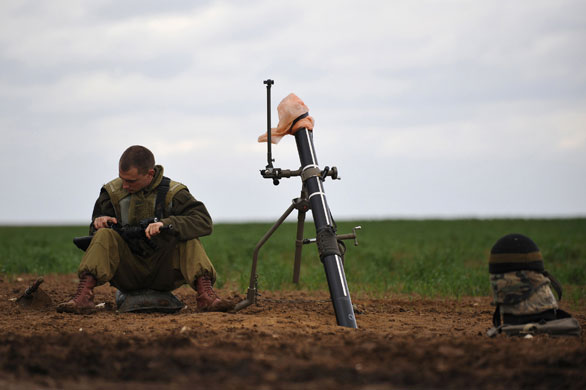 Gallery gaza pm updated: An Israeli soldier sits beside a mortar launcher 