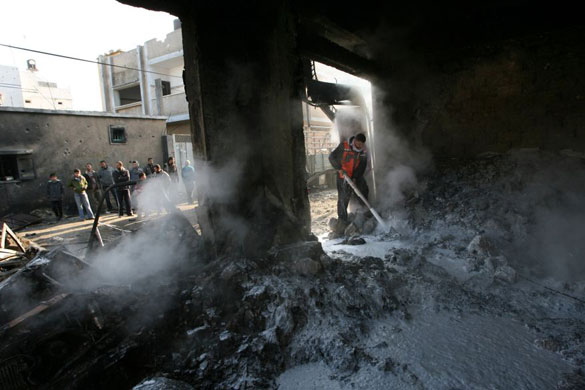 Gallery 12 January 2009: Palestinian civil defence members extinguish a fire in a house