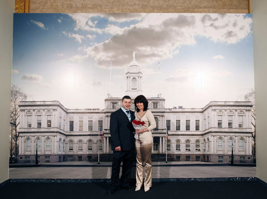 Gallery 24 hours in pictures : A married couple pose next to a mural of City Hall in Manhattan 