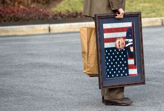 Gallery 14 January 2009: A White House staffer carries a framed photograph George Bush