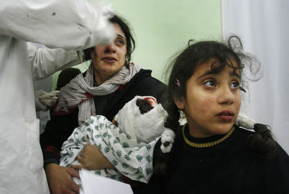 Gallery 14 January 2009: Beit Lahiya, Gaza Strip: A doctor treats a wounded mother, daughter and son