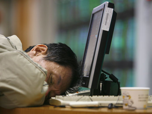 Gallery 24 hours in pictures : A man sleeps after monitoring stock market prices   in Taiwan