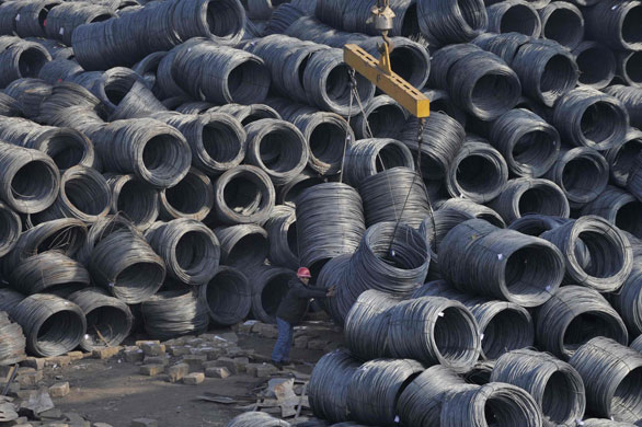 Gallery Business week: A worker handles steel wire rod coils at a steel market in China