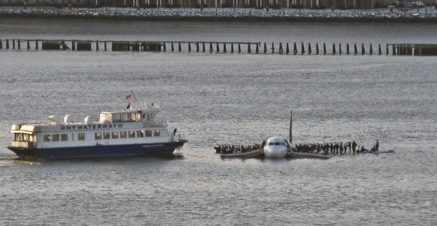 Airline passengers wait to be resuced on the wings of a US Airways plane