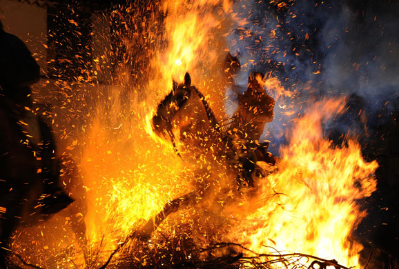 Gallery 24 hours in pictures: A horseman jumps over a bonfire 