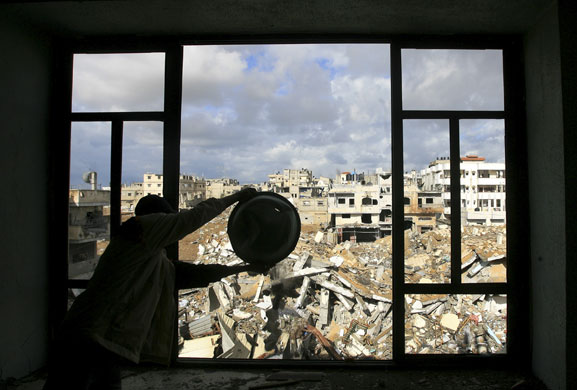 Gallery Withdrawal from Gaza: A Palestinian man clears the rubble out of his house