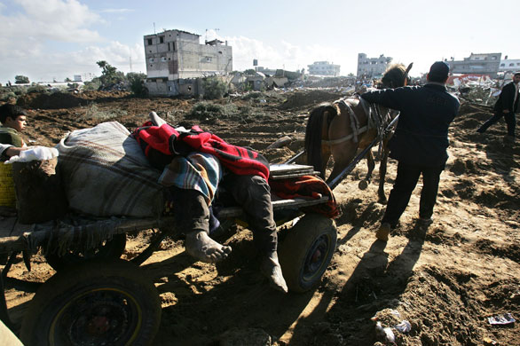 Gallery Withdrawal from Gaza: A Palestinian man removes the body of Hamdi Al-Samoni