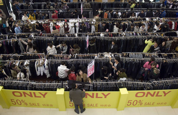 Gallery 24 hours in pictures: ustomers select clothes at a 'fifty discount sale' clothes stall 
