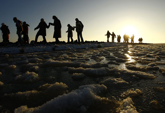 Gallery 24 hours in pictures: People walk along the iced shore at the North Sea