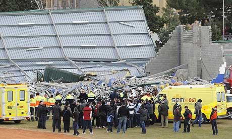Rescuers work at a sports centre which collapsed in high winds killing four children in Spain