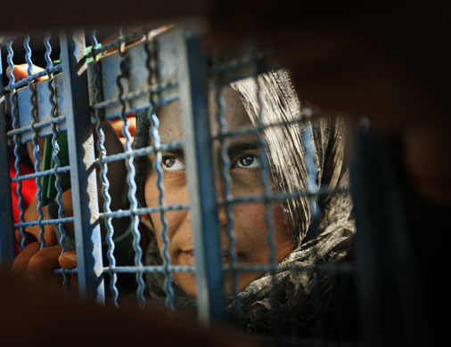 Gallery 24 hours in pictures: Woman waits to receive aid at a UN food distribution centre in Gaza