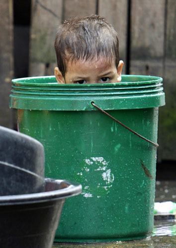 Gallery 24 hours in pictures: A boy is seen inside a bucket as he takes a bath at a slum area in Manila