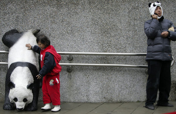 Gallery World Chinese New Year: A girl touches a panda statue