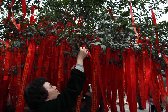 Gallery World Chinese New Year: A worshipper hangs a string