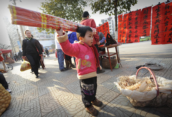 Gallery World 2 chinese new year: A young boy holds fireworks