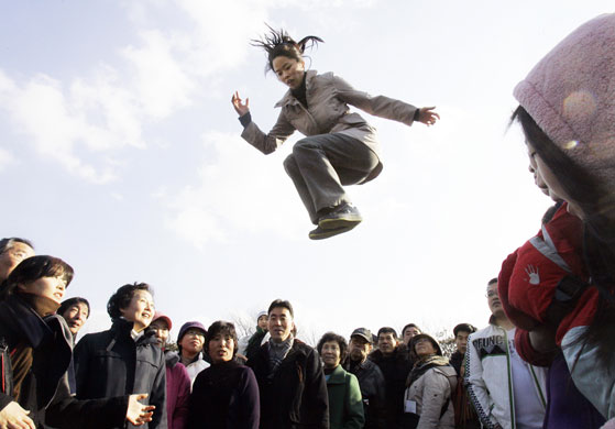 Gallery 27 January 2009: Seoul, South Korea, A woman jumps into the air as she plays on a seesaw