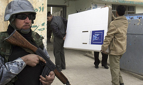 A police officer stands guard outside a polling centre in Mosul, Iraq