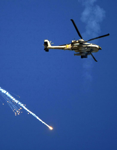 Gallery Israeli troops enter Gaza: An Israeli Apache helicopter releases a flare inside Gaza Strip