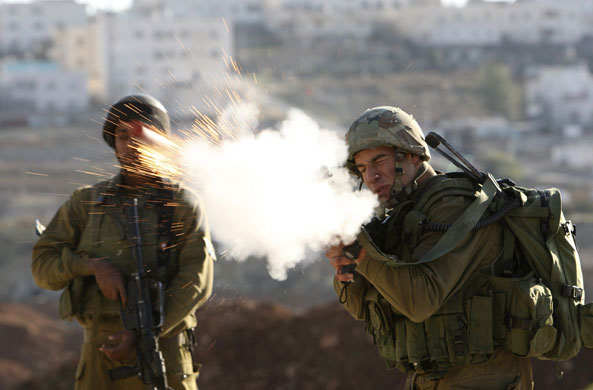 Gallery 24 hours in pictures: Israeli soldier fires tear gas during protest in Hebron