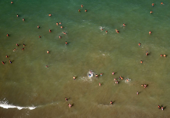 Gallery 24 hours in pictures: Puerto Madryn, Argentina: Locals at the beach are seen from the air 
