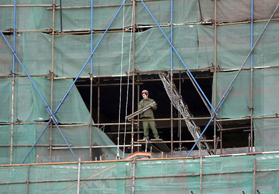 Gallery 6 January 2009: Beijing, China: A worker moves the scaffolds at a construction site
