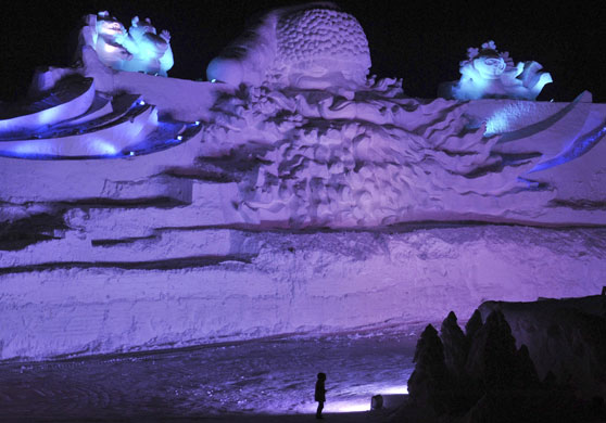 Gallery Harbin: A visitor stands in front of a giant Santa Claus ice sculpture in Harbin