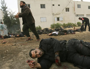 A wounded Palestinian policeman gestures 