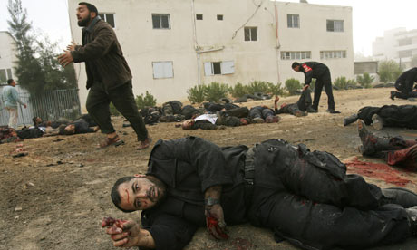 A wounded Palestinian policeman gestures 