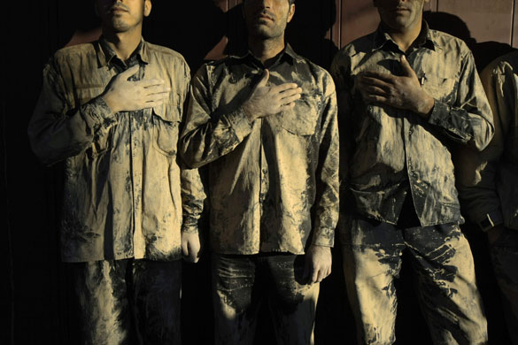 Gallery 24 hours in pictures : Iranian men covered in mud place their hands to their chests during Ashura 