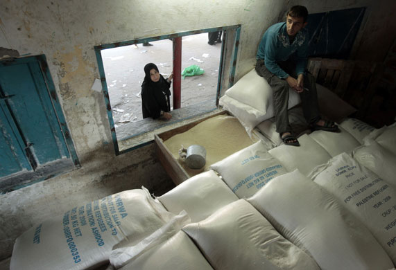 Gallery Gaza: Palestinian woman waits to receive food supplies at UNRWA hq in Gaza