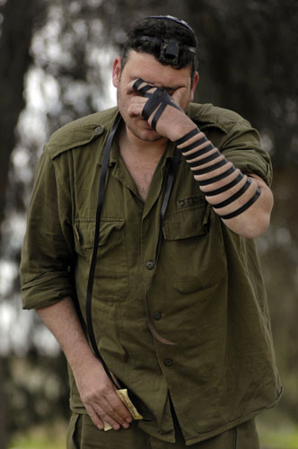 Gallery Gaza conflict: day 13: An Israeli soldier prays near border with Gaza