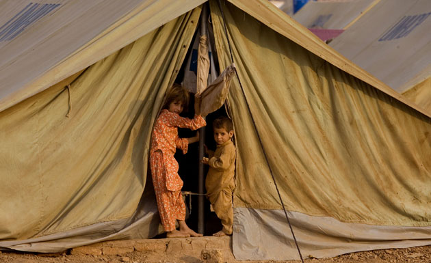 Gallery Children in Pakistan: Children from Bajur look outside their tent in a refugee camp