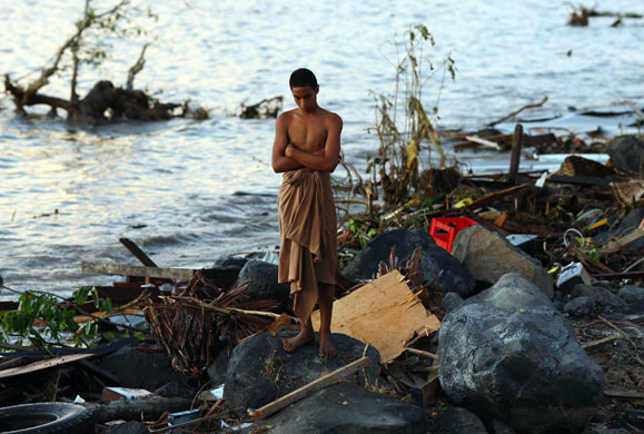 Samoa: A man looks at the debris at the waterfront in Lalomanu