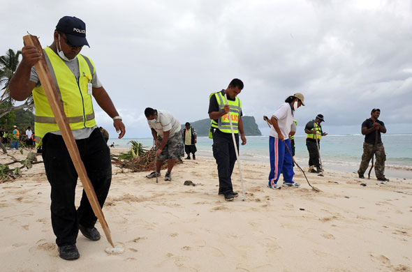 Samoa: Police use poles to poke through the sand