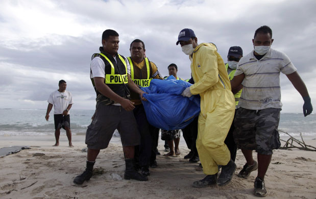 Samoa: Police carry the body of a tsumani victim