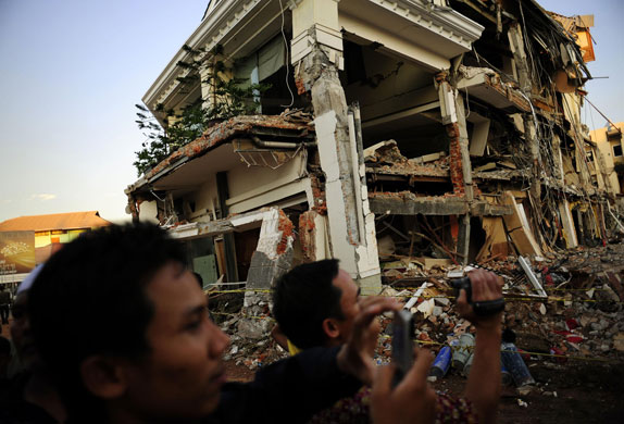 24 Hours in Pictures: Locals photograph the earthquake-destroyed Ambacang Hotel in Padang