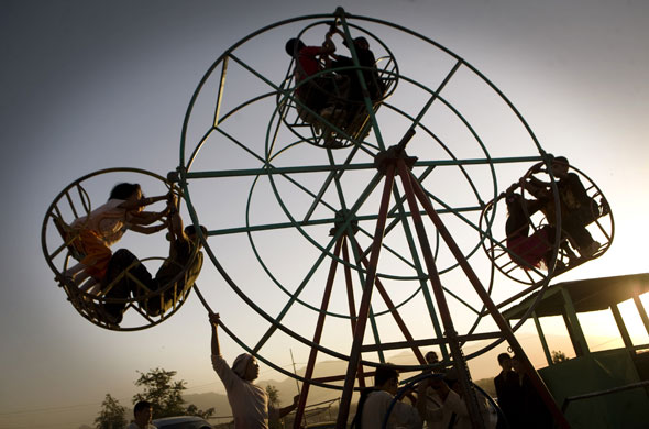24 Hours in Pictures: Afghan children enjoy a swing in Kabul