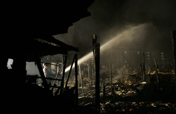 Sao Paulo Brazil fire: A firefighter sprays water at the site where a fire broke out in a slums