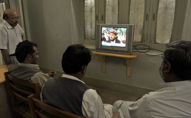 Pakistan: 5 October 2009: People watch a broadcast of Taliban chief Hakimullah Mehsud