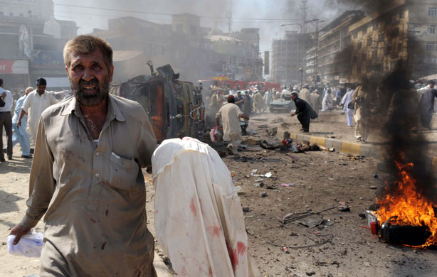 Pakistan: 9 October 2009: Bystanders gather at the site after a car bomb blast