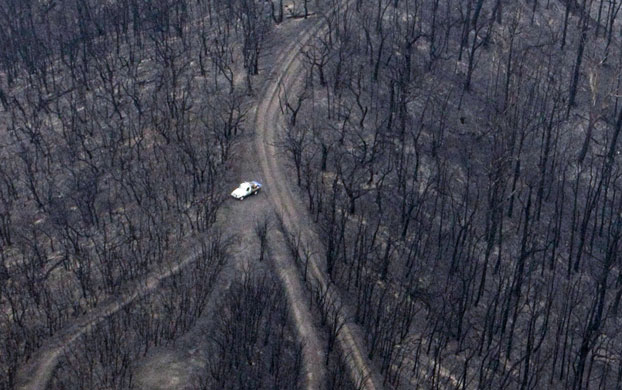 10 years: A vehicle near the remains of a house destroyed by bushfires in Kinglake