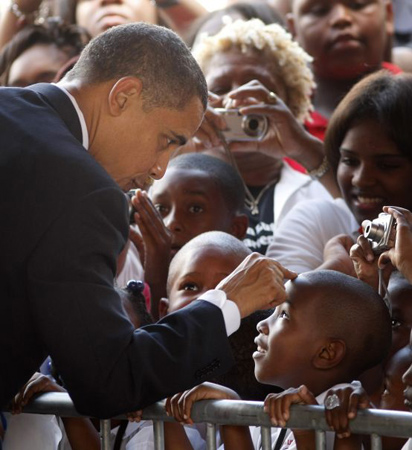 Barack Obama touches a boy's head at Dr Martin Luther King charter school in New Orleans