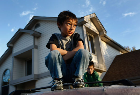 Balloon boy: Falcon Henne sits outside his home in Colorado
