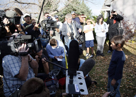 Balloon boy: Falcon Heene is surrounded by reporters on the lawn of his house