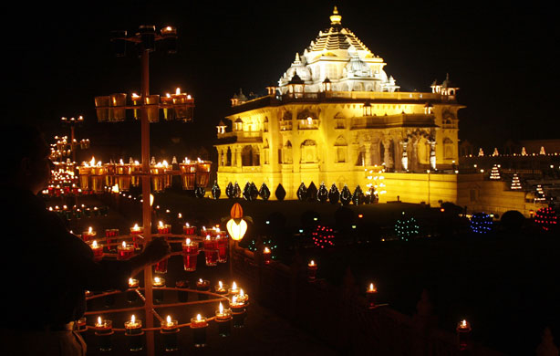 Diwali: A devotee lights a lamp at Akshardham temple at Gandhinagar, India