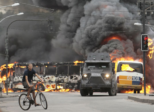 Rio de Janeiro: An armoured police vehicle near two public buses set on fire