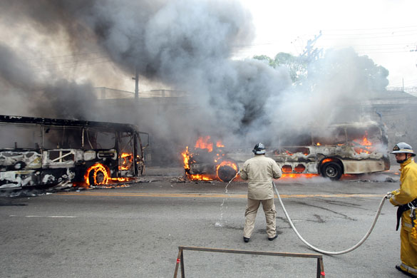 Rio de Janeiro: Firefighters work on two buses set on fire by drug dealers