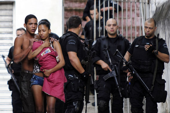 Rio de Janeiro: A couple carrying a child leaving the Macacos slum